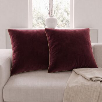 Bordo altın biyeli kare kırlent kılıfı 2'li set, bir koltuğun üzerinde; 50x50 cm.